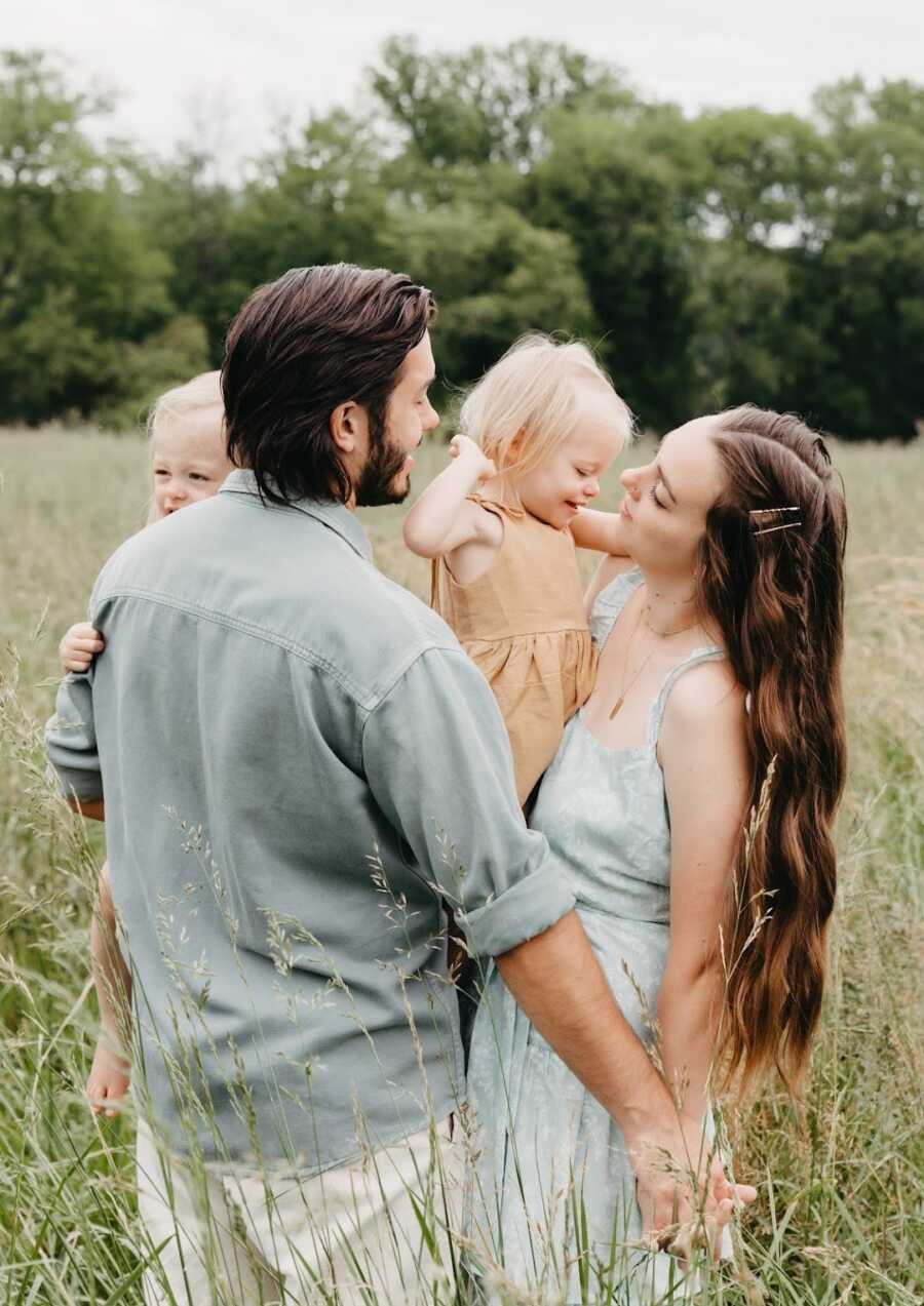 mother, father and twin girls in a field