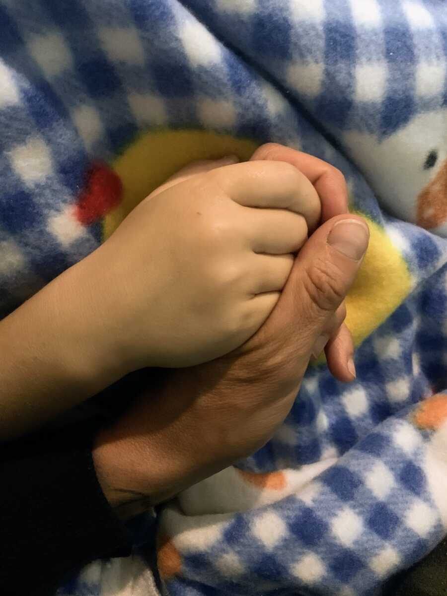 mother holding dying infant daughter's hand