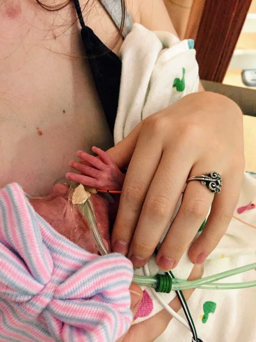 mother holding the hand of her early born daughter