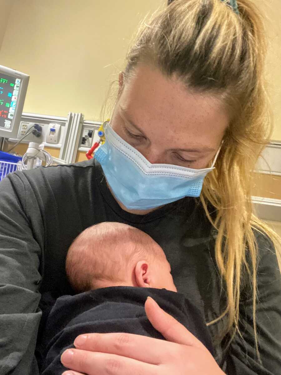 mother wearing a medical mask holding her infant son