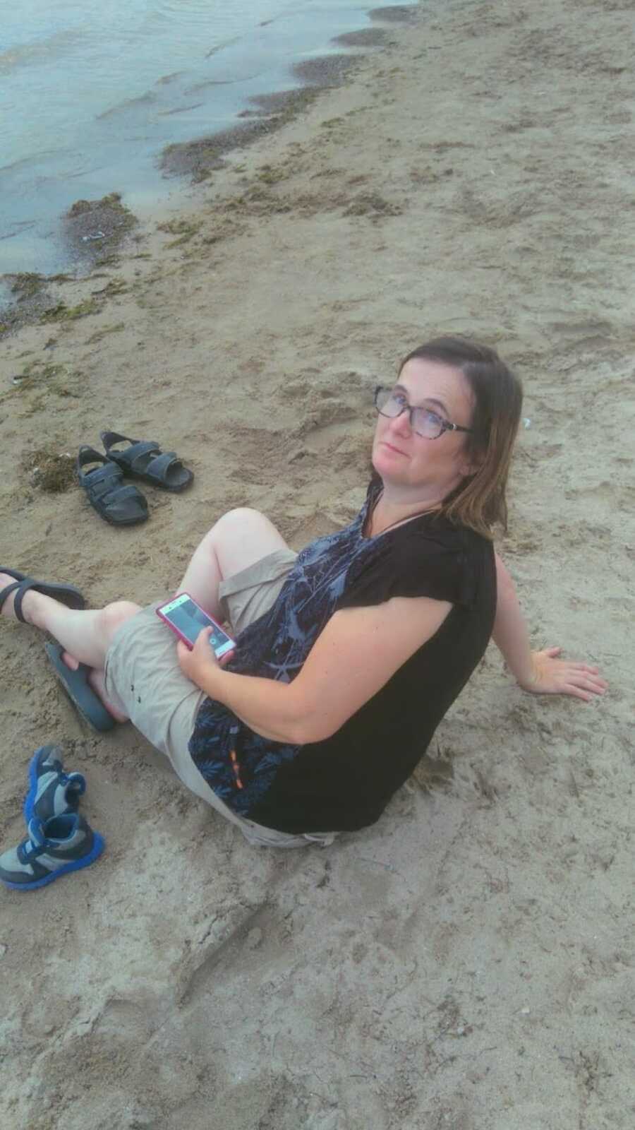 mother during weight loss journey sitting on the beach