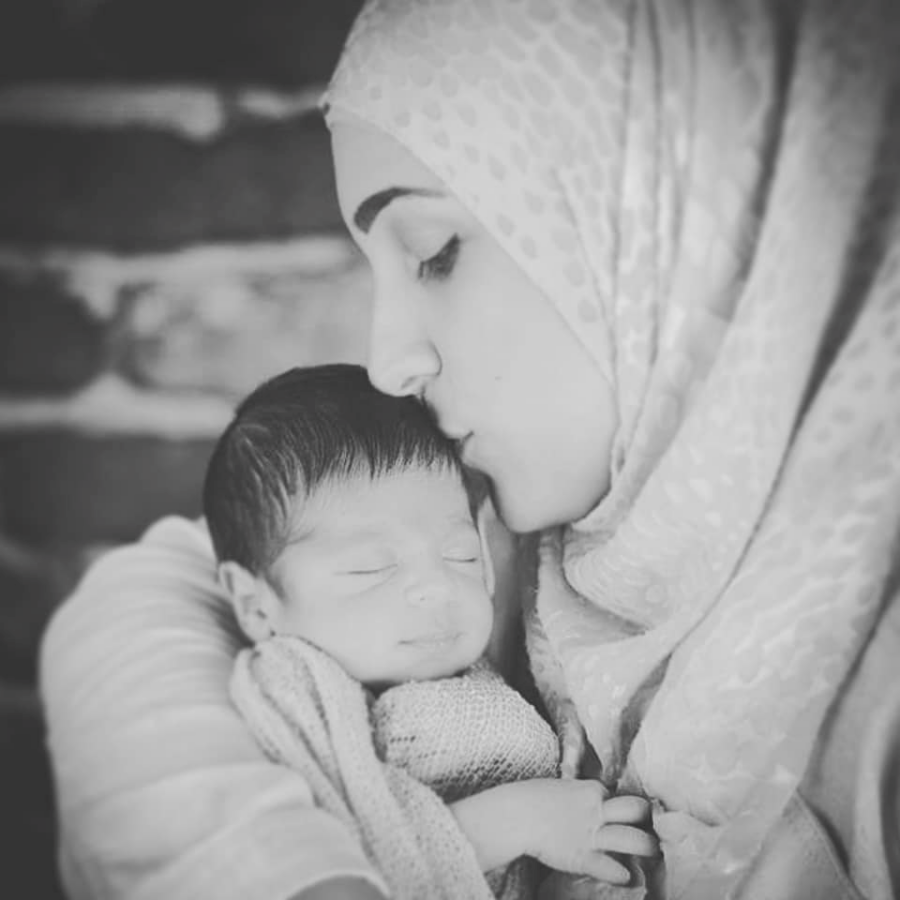 New mother with postpartum despression kissing newborn baby