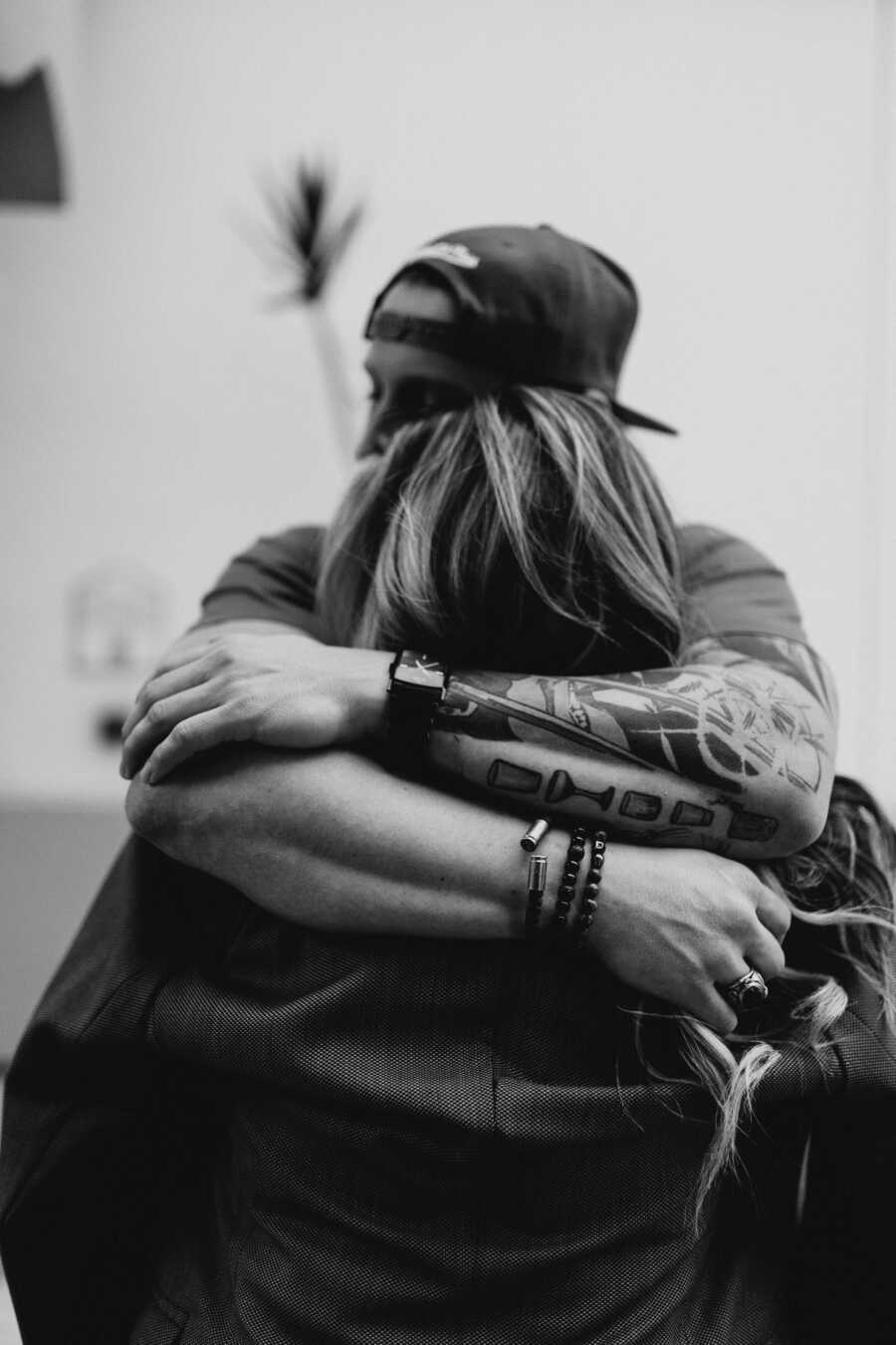 black and white photo of husband and wife hugging each other