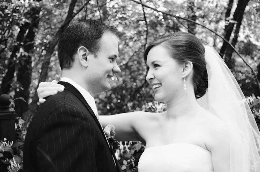 black and white wedding photo of bride and groom smiling at each other