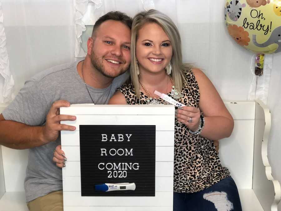 husband and wife with positive pregnancy announcement