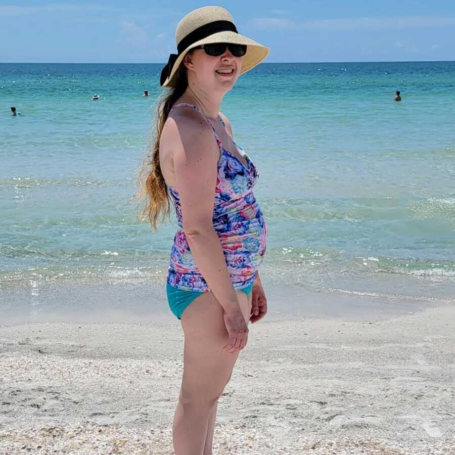 pregnant mother standing on beach