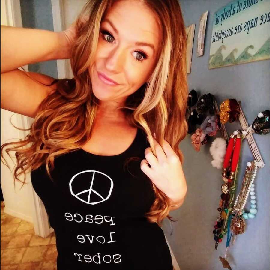 recovering alcoholic wearing tank-top saying peace, love, sobriety