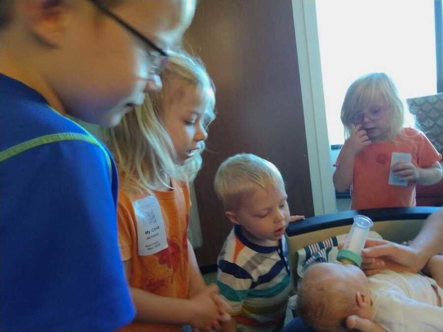 siblings gather around adopted brother with Down Syndrome