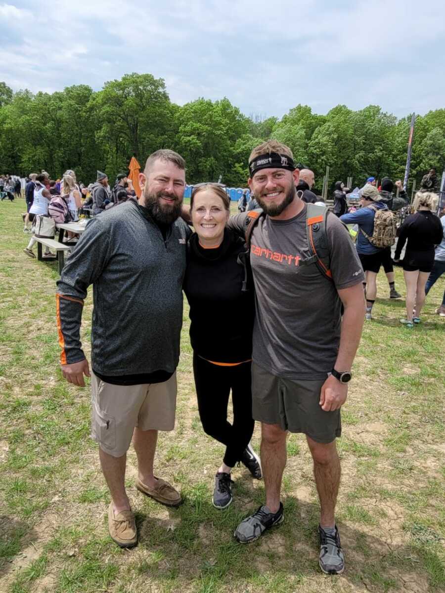 siblings found from DNA test posing for photo in park field.