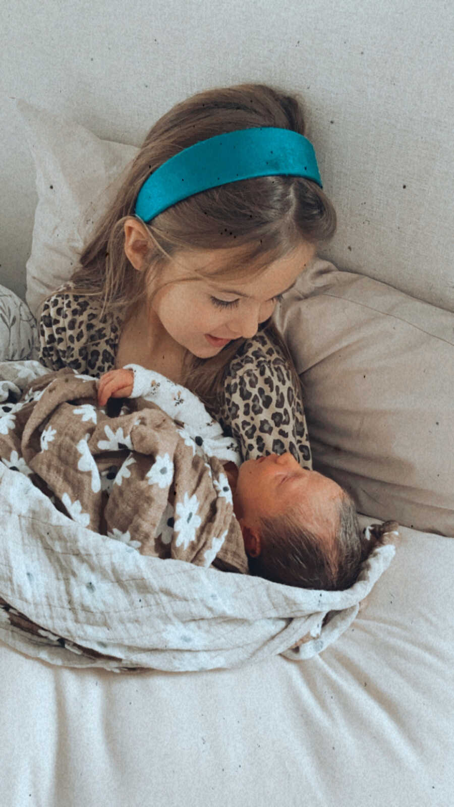 older sister holds her newborn sister