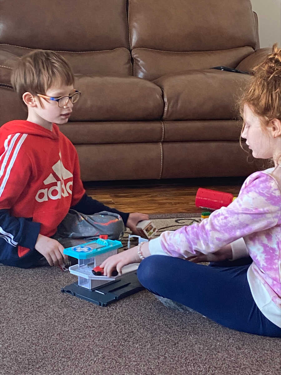 Younger sister plays with her autistic brother 