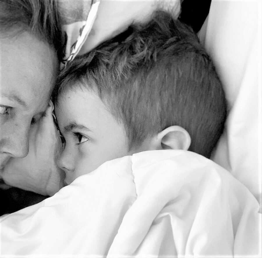 mom to medically complex child laying in bed with son