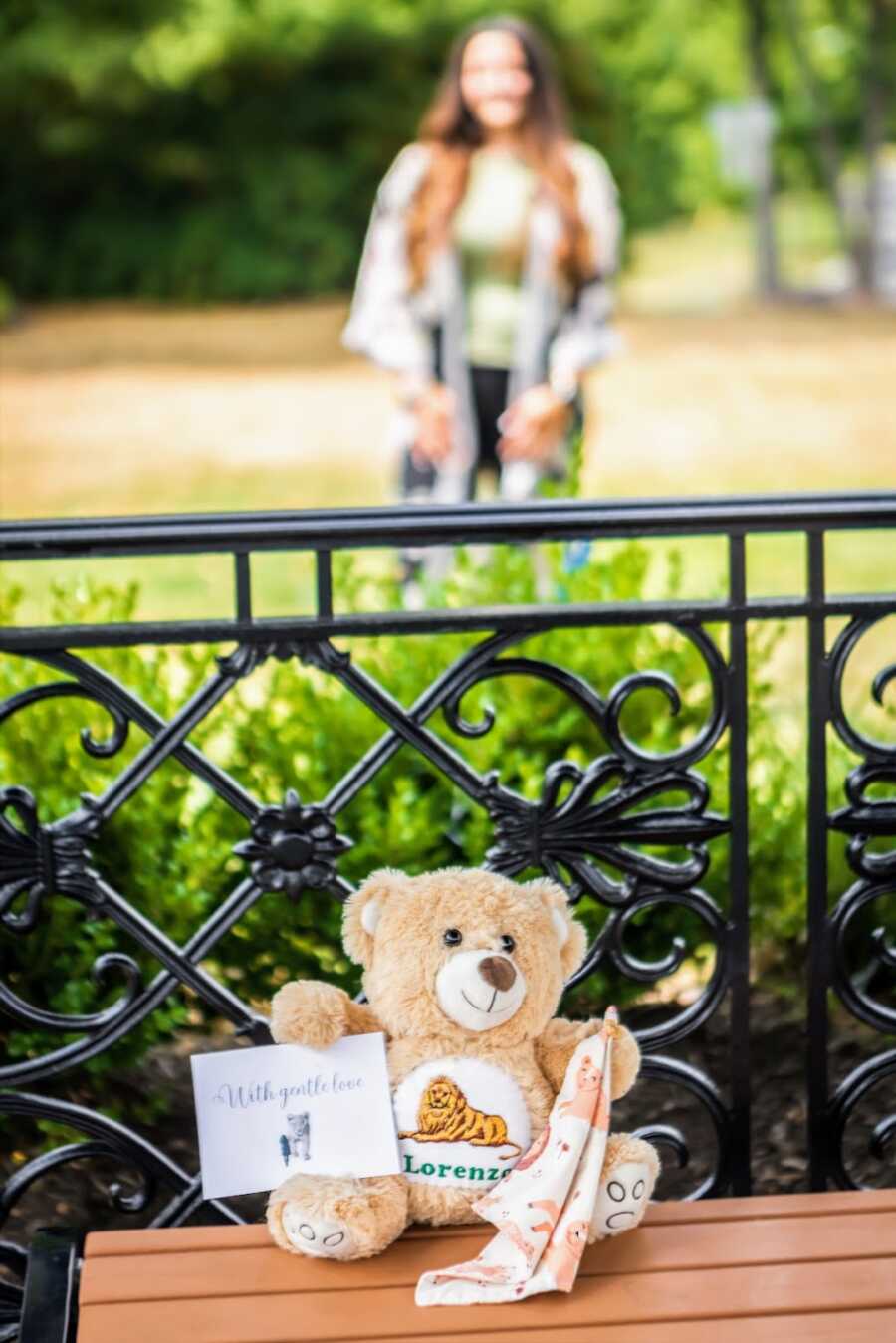 teddy bear honoring dead son with mother standing in garden behind