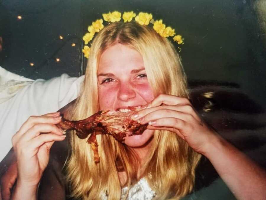 teenage girl with flower crown eating chicken