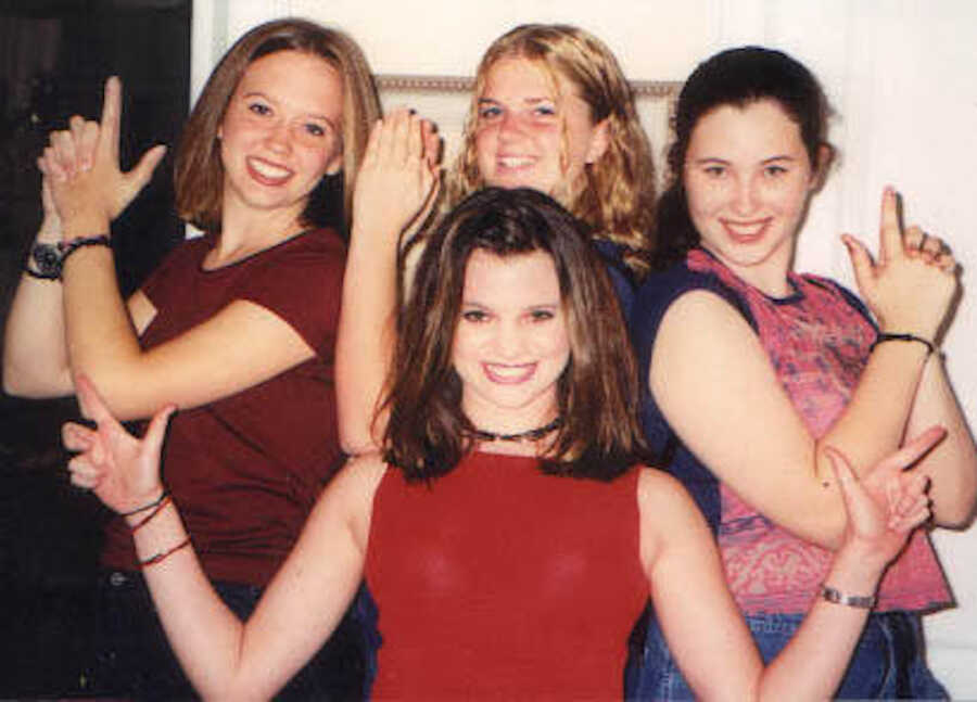 four teenage girls posing with finger guns