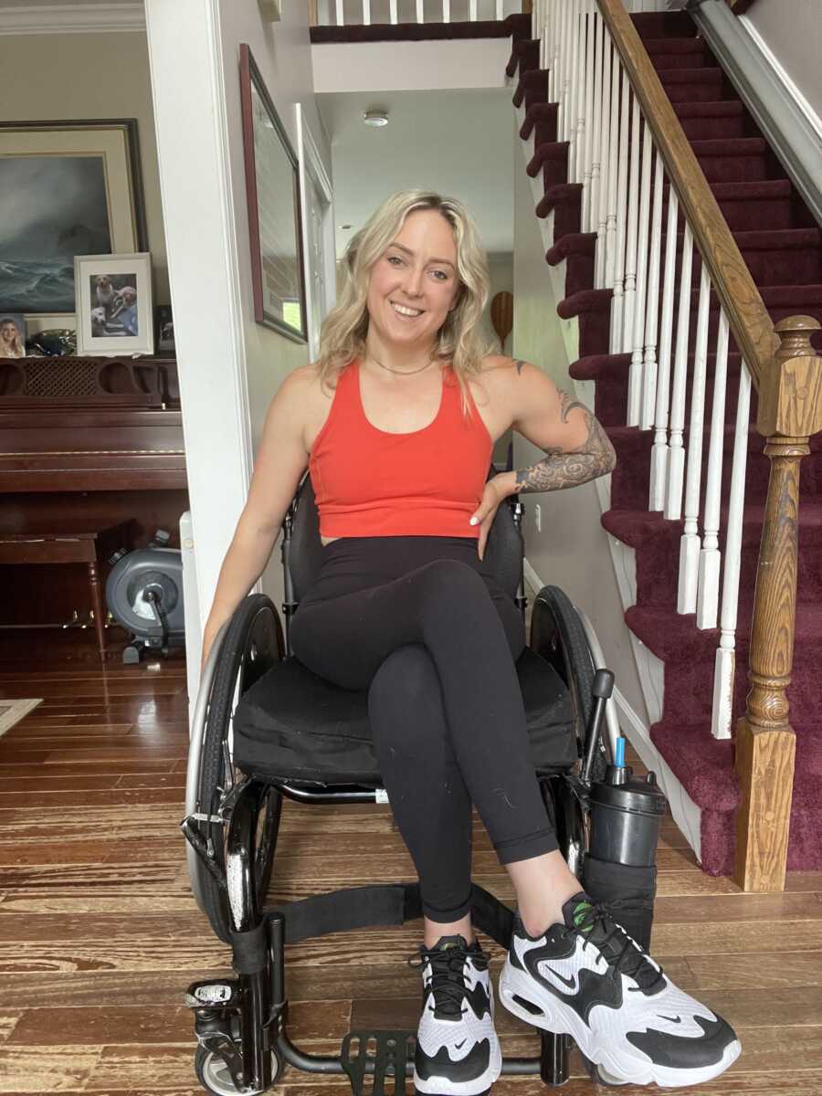 Wheelchair user poses in her house in workout clothes