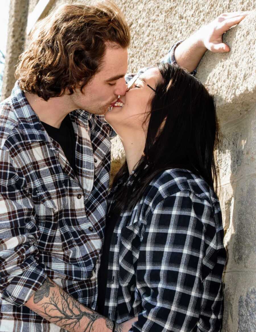 husband and wife kissing while smiling