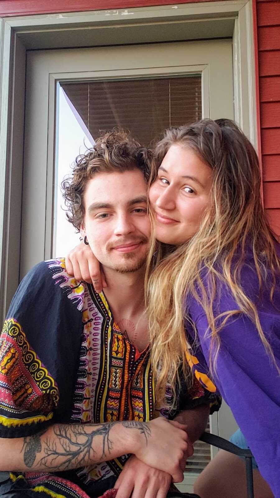 husband and wife smiling together on porch