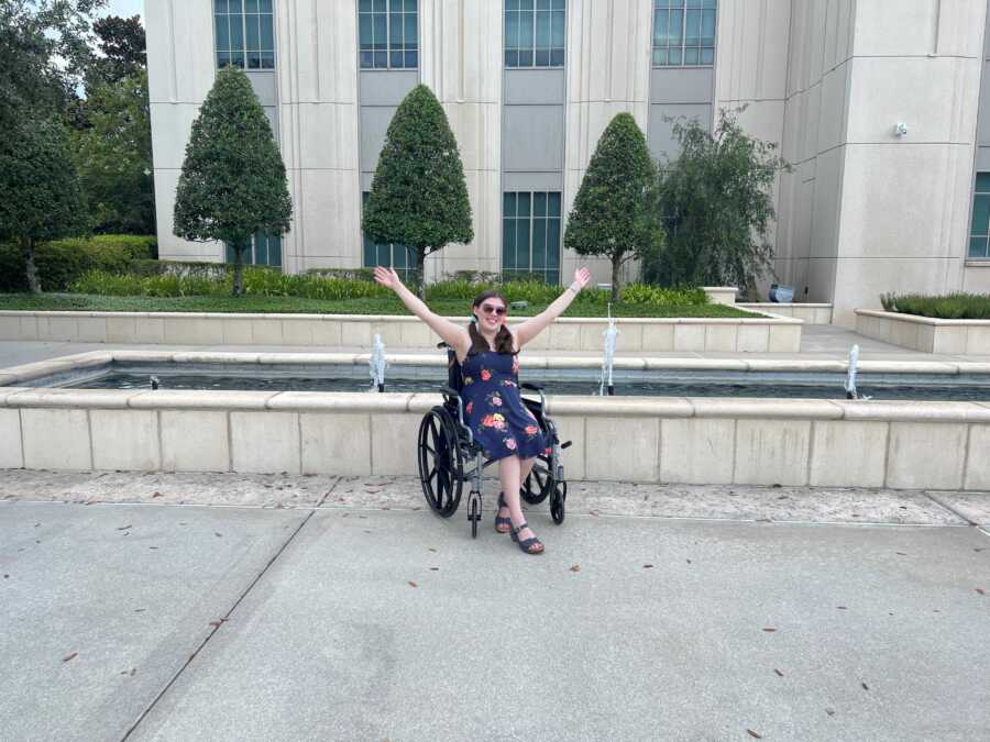 chronic illness survivor in front of water fountain