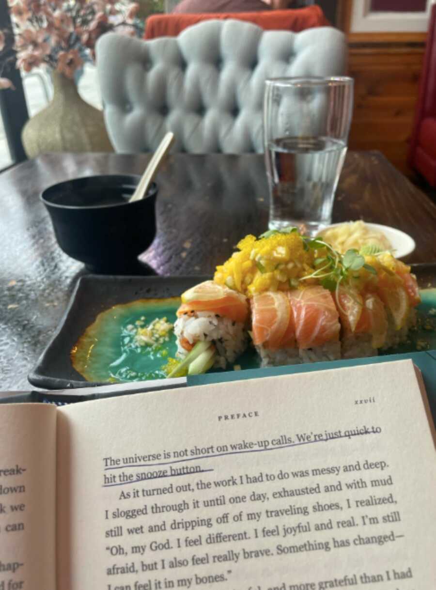 career driven mom photographs sushi with a book in front of it