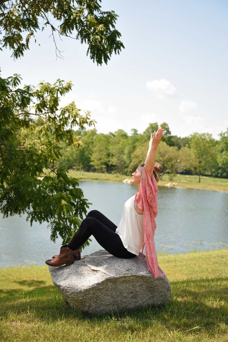 woman sitting by a lake