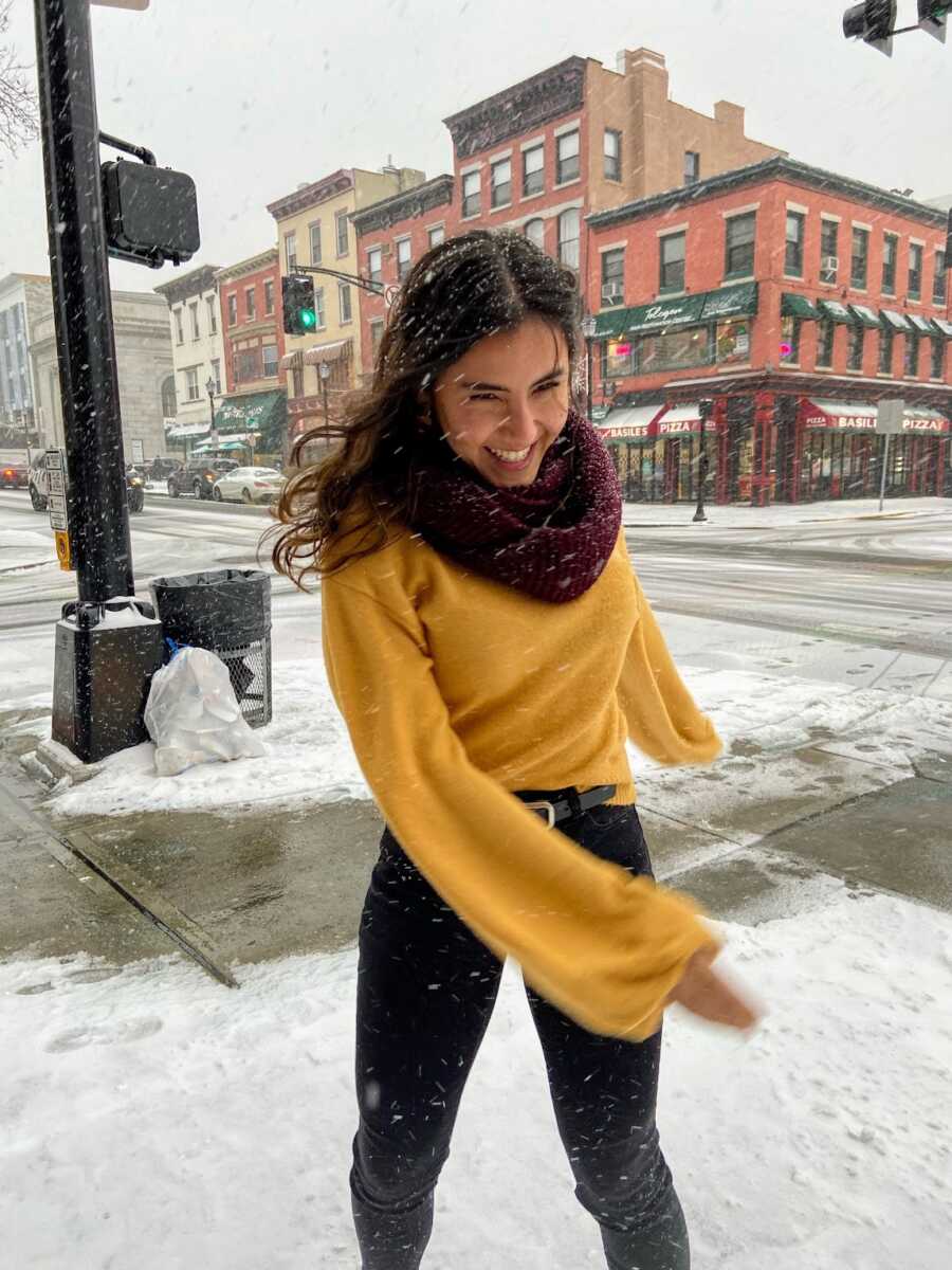 woman smiling in New York while it's snowing