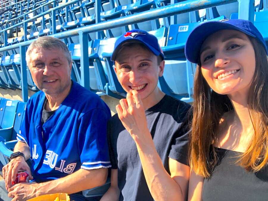 woman takes a selfie with friends at baseball game