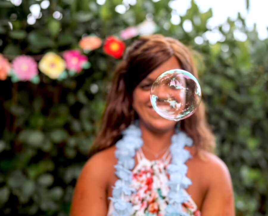 woman with dwarfism plays with bubbles