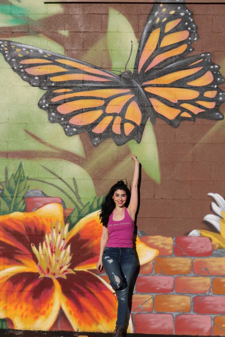 woman posing with butterfly mural