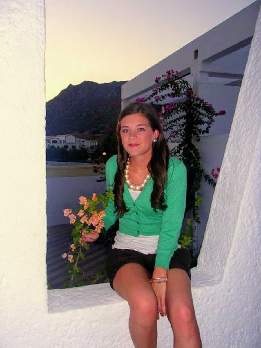 young woman sitting in an empty, white window