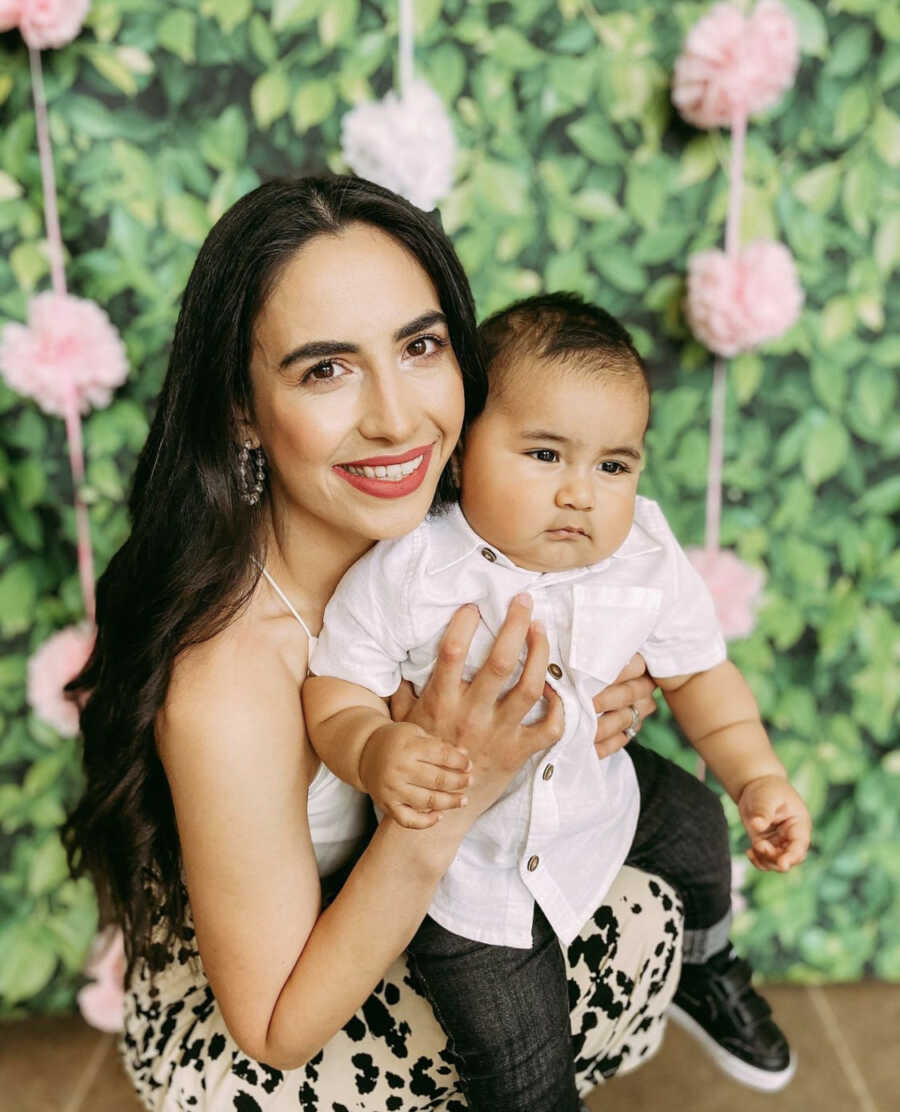 Married mom holding toddler son at a party