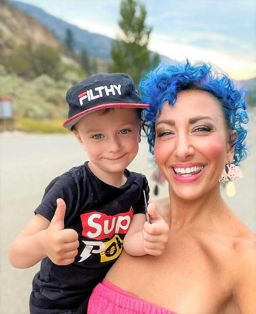 Son giving a thumbs up next to Mom with short, blue hair defying society standards of how mom should look and dress