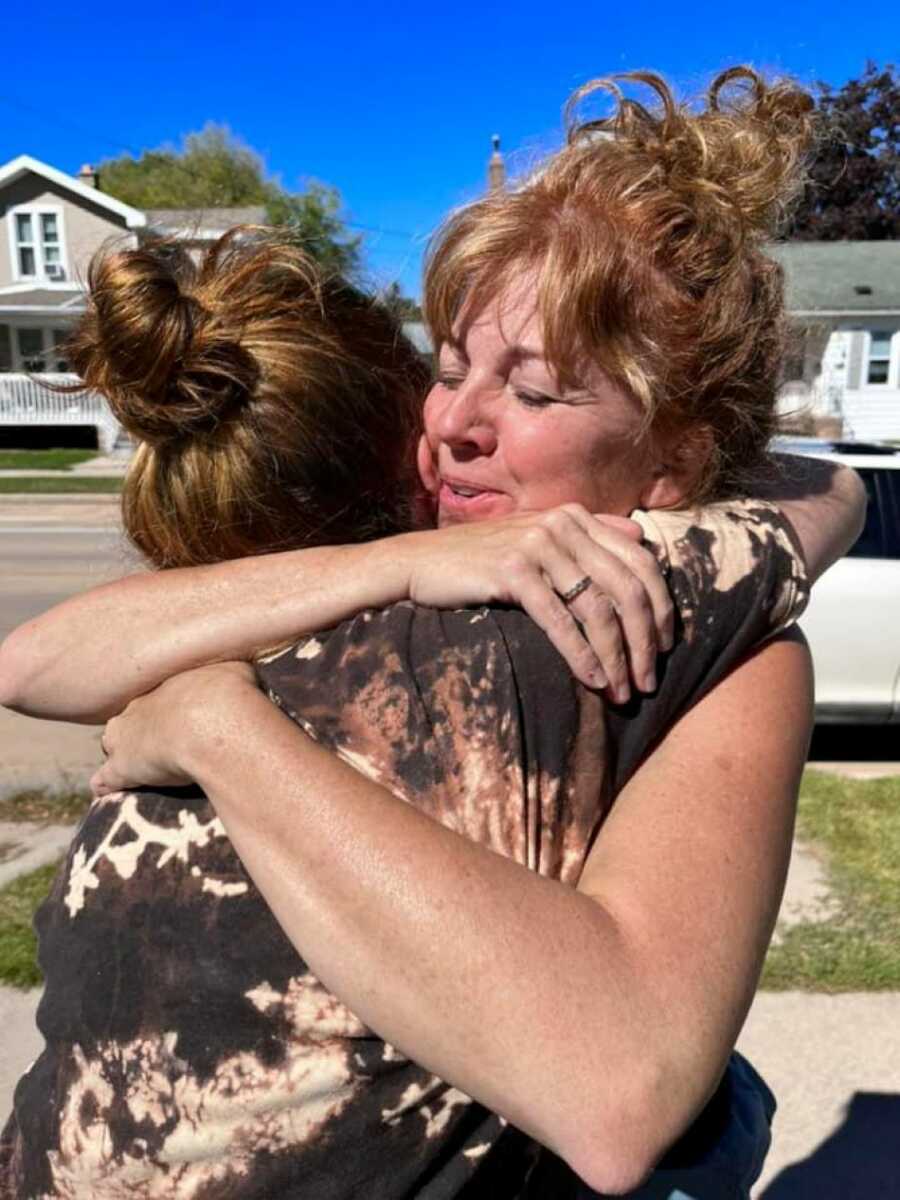 Mother giving daughter tight hug