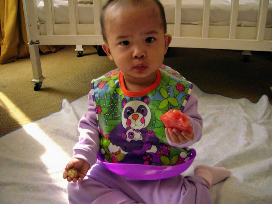 adopted daughter sitting on the floor eating watermelon