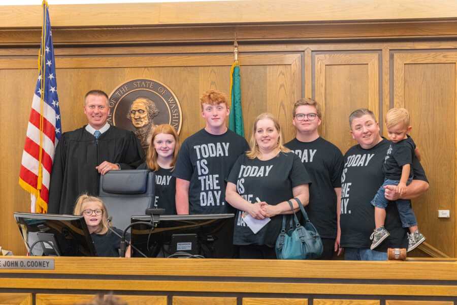 family in courthouse with judge on adoption day