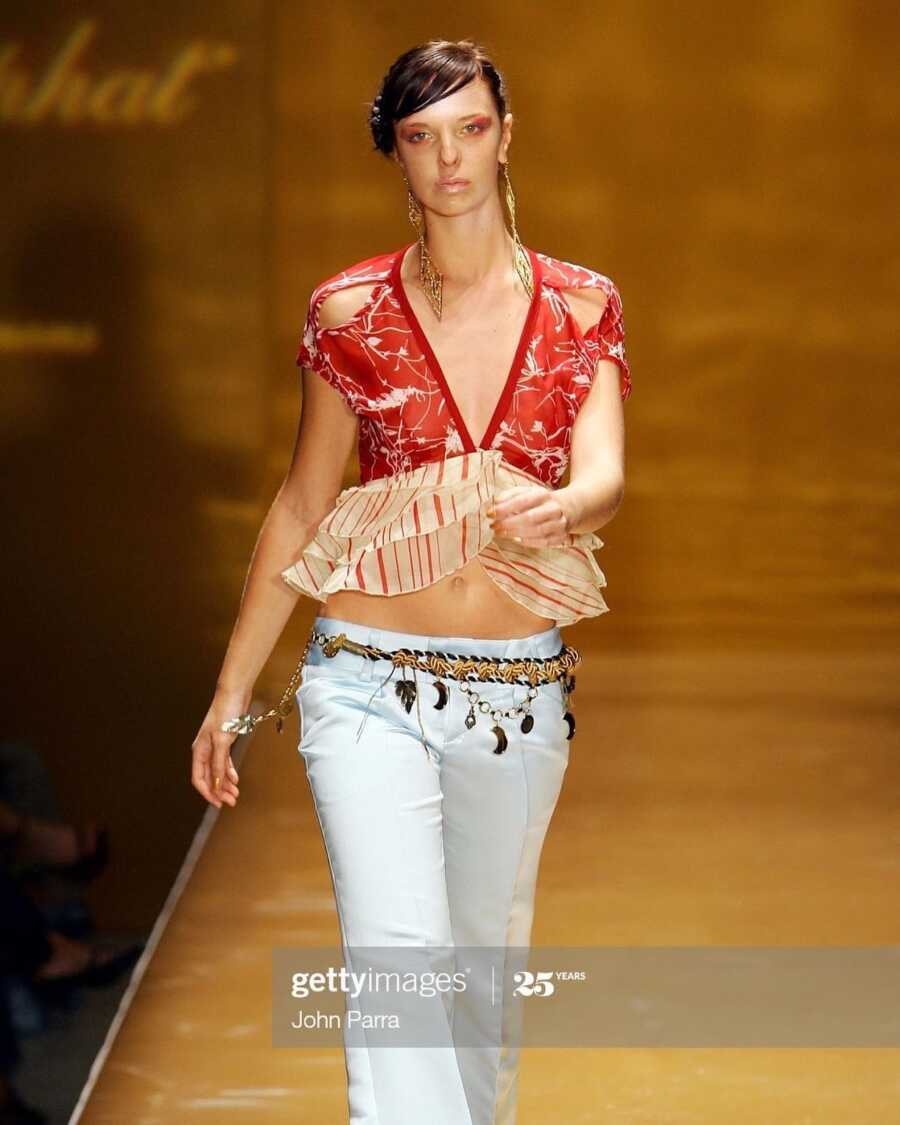 alcoholic young woman walking down modeling runway in red top