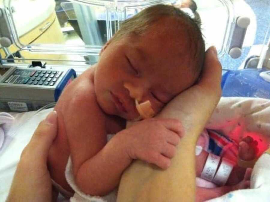 Newborn baby sleeping in NICU bed