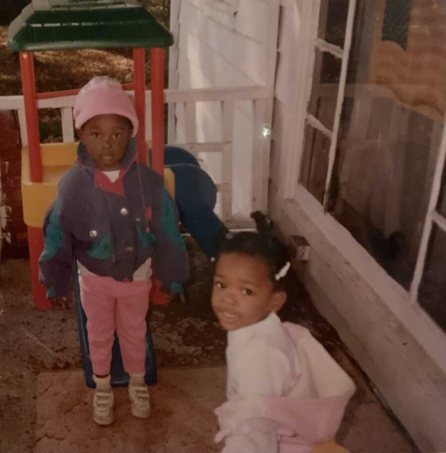 biological siblings standing together playing