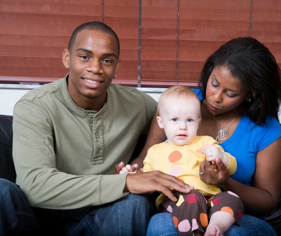 black couple holds transracial adopted baby