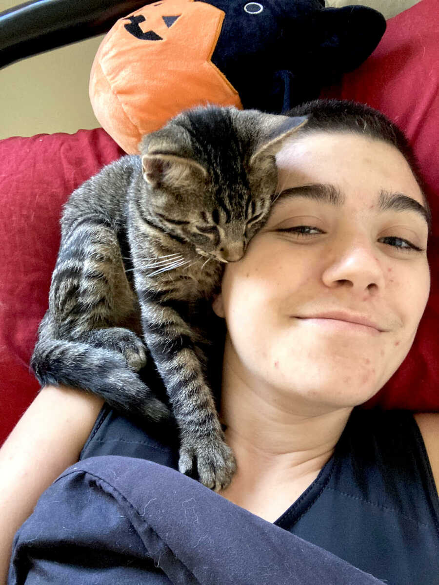 chronic illness warrior with cat laying on their shoulder