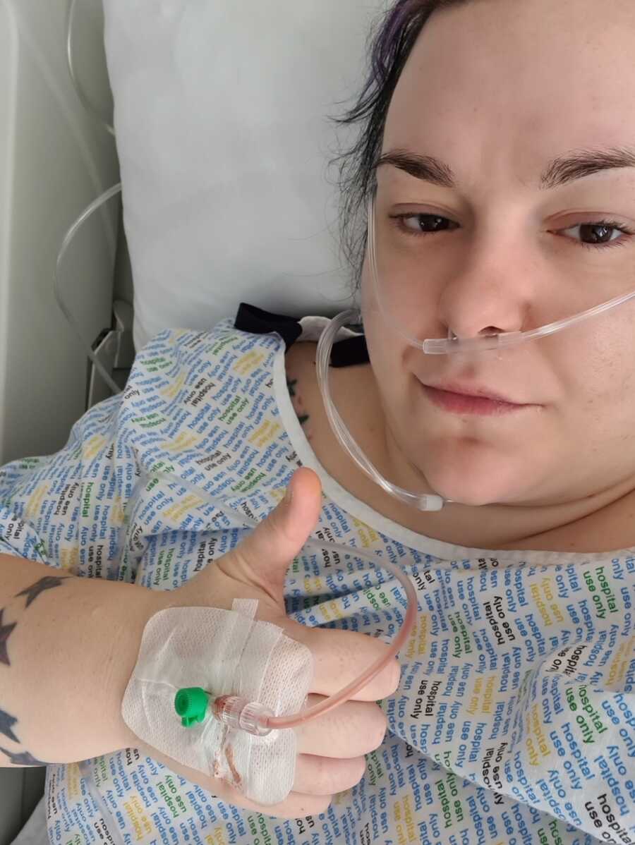 chronically ill woman in hospital bed with IV and oxygen