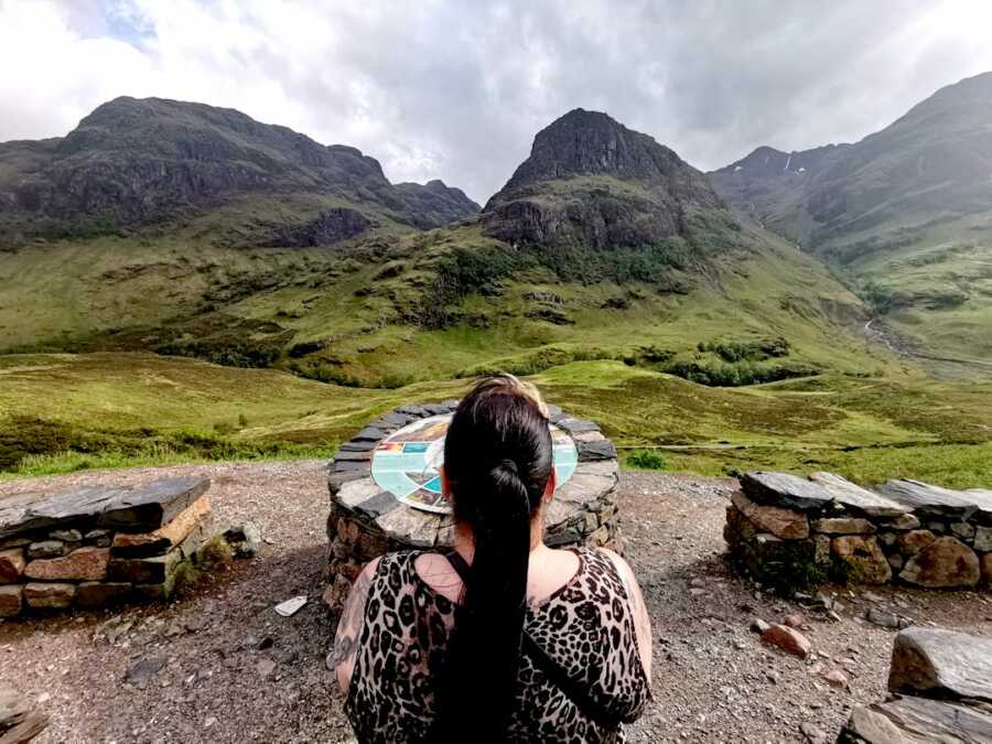 chronically ill woman looking out at greenery and mountains