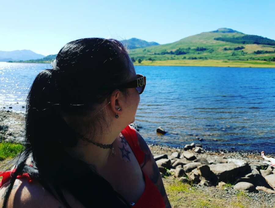 chronically ill woman looking out at lake scenery