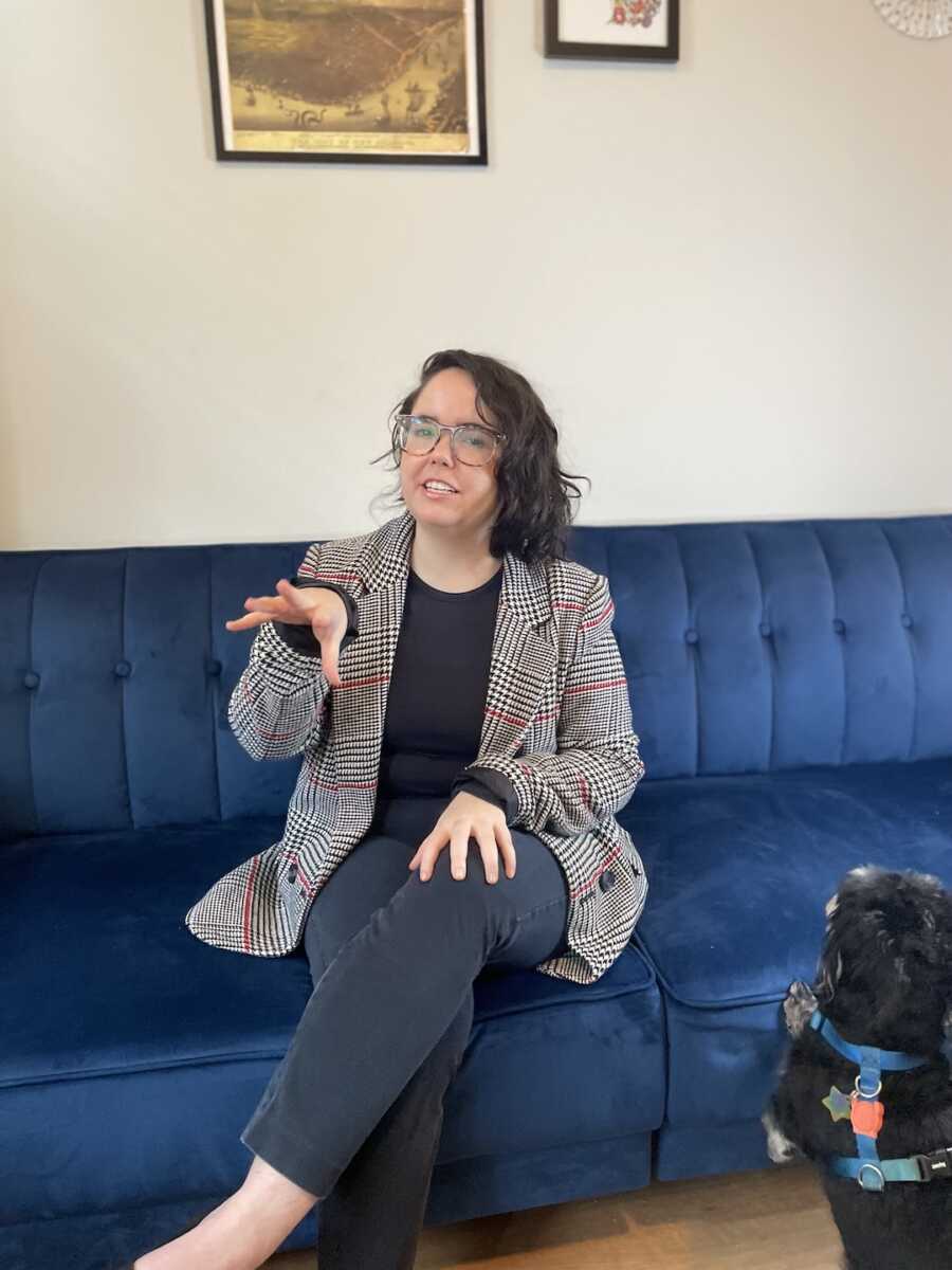 chronically ill woman sitting on a blue couch in professional attire