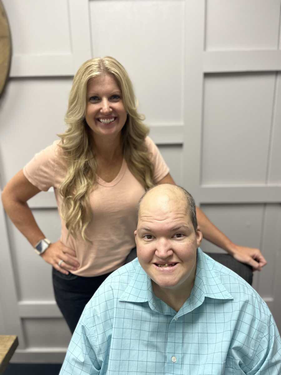 Younger sister poses with brother with chromasonal disability