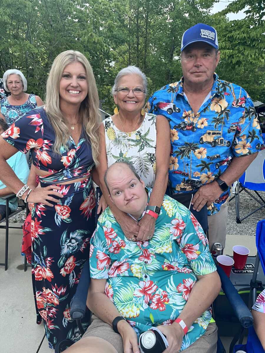 Mom, dad, sister, and older brother with disability in tropical shirts 