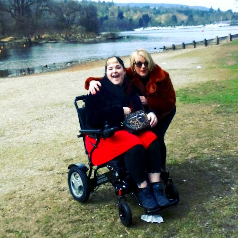 disabled chronically ill woman in wheelchair with a friend