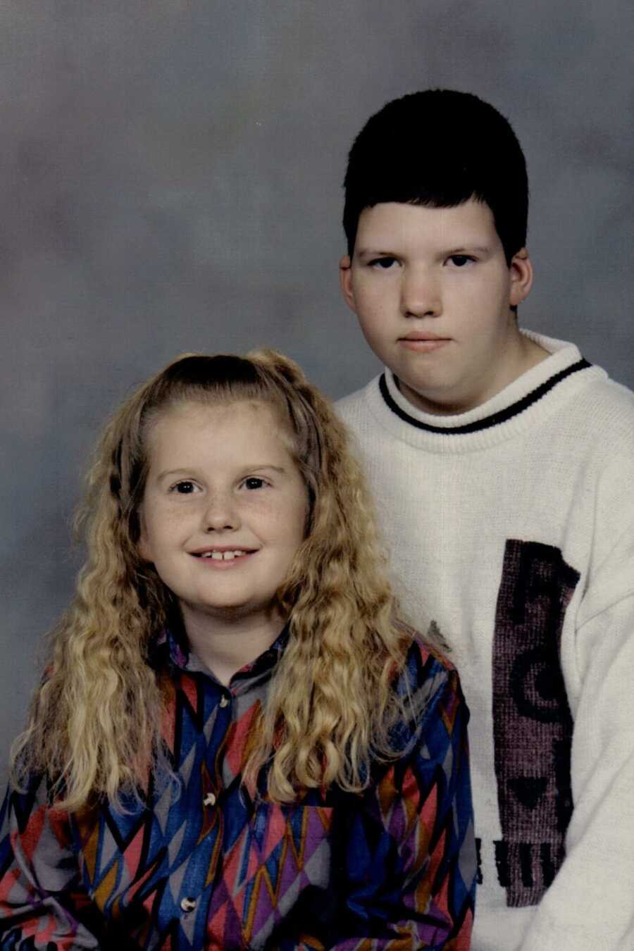 Sister and her older brother with chromasonal disability pose for photo