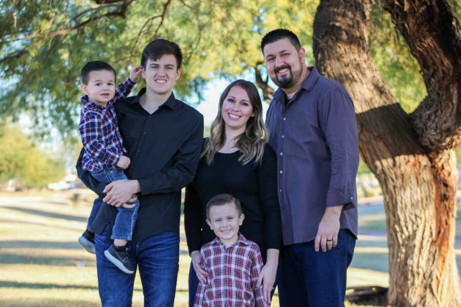 woman with chronic pain stands with her husband and three sons