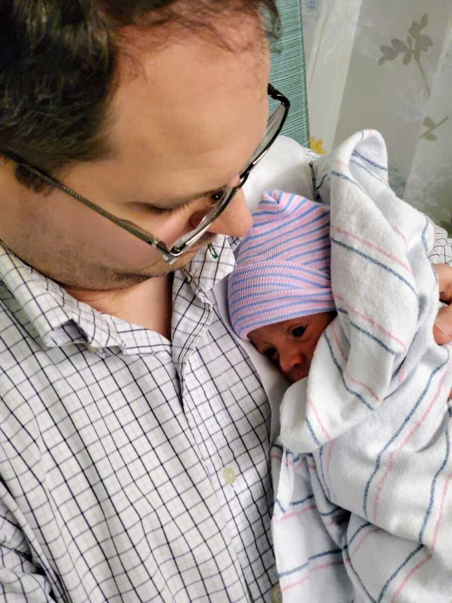 father holding his adopted son in the NICU